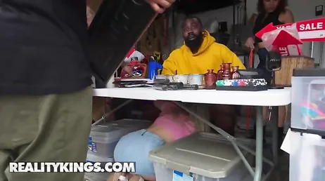 Die Blondine kriecht unter den Tisch und lutscht weiter an einem riesigen schwarzen Schwanz.